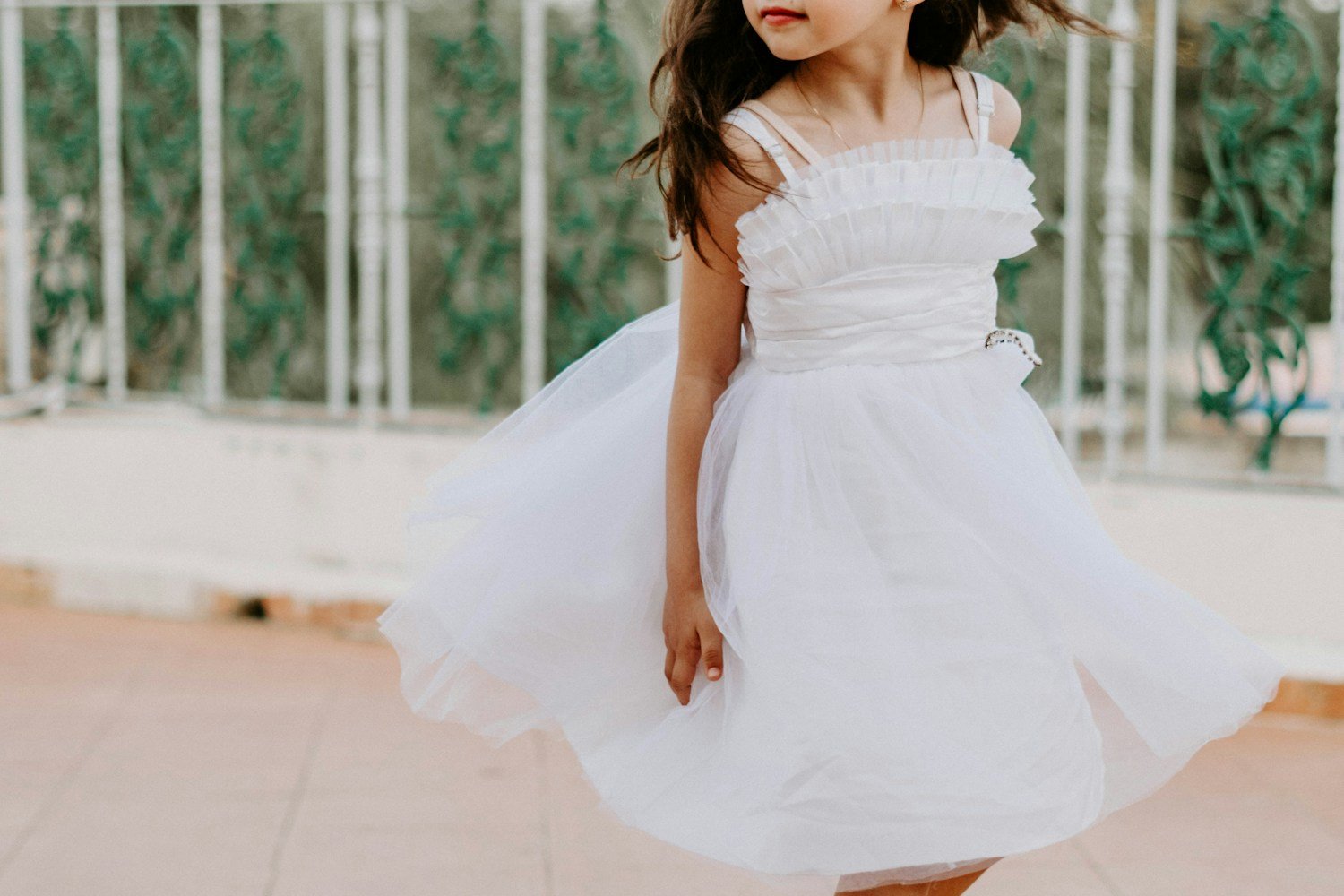 Niña bailando con vestido blanco de fiesta — Emma Velázquez Infantil